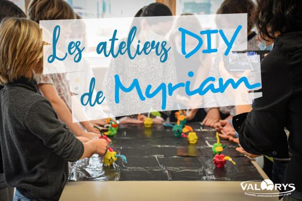 Le logo des ateliers de Myriam, en arrière plan des enfants autours d'une table